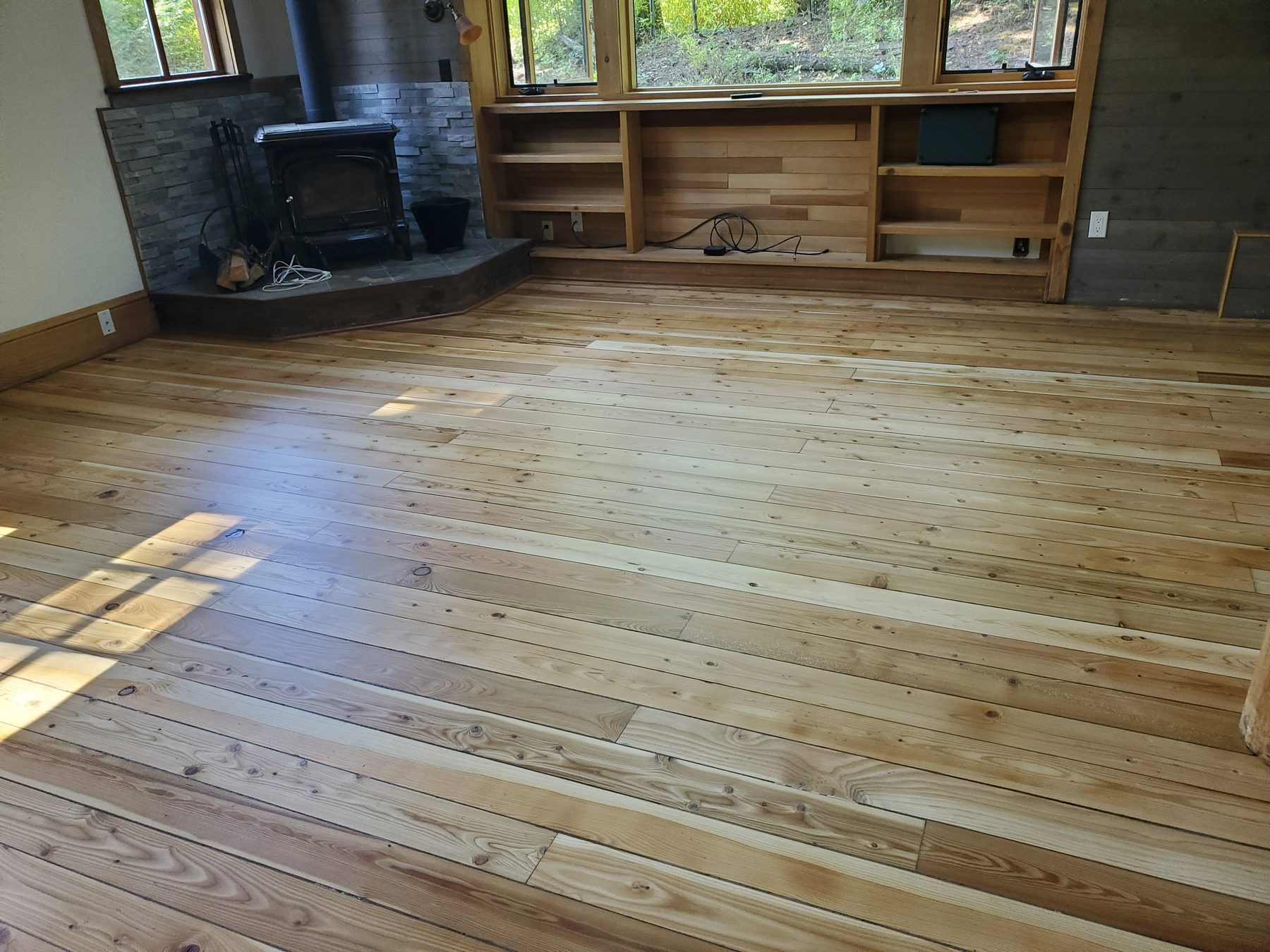 Refinished knotty pine plank floor in a living room